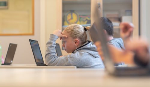 Elever arbetar med datorer i ett klassrum