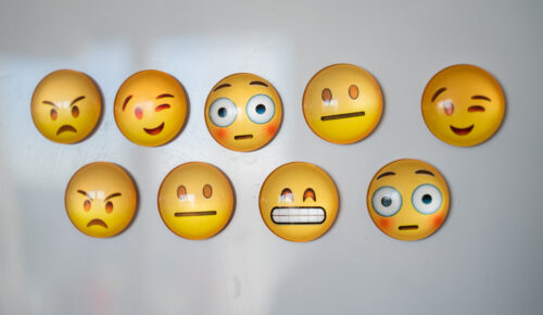 Emojis med olika uttryck på vit yta.
