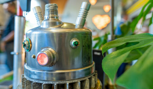 Närbild på en robot med gröna lampor som ögon.