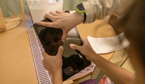 Två barn tittar på en ipad tillsammans.